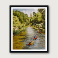 Kayakers drifting along the San Antonio River Walk surrounded by green trees